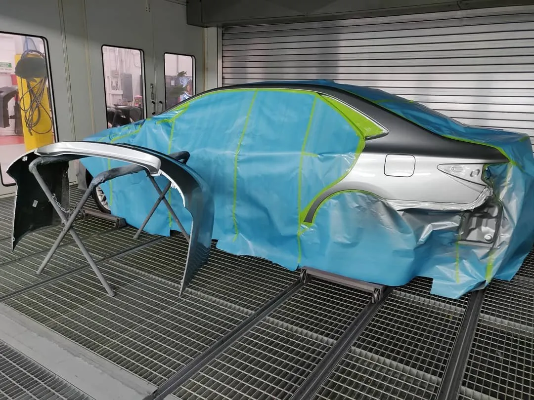 A vehicle masked and prepped for paint in the booth